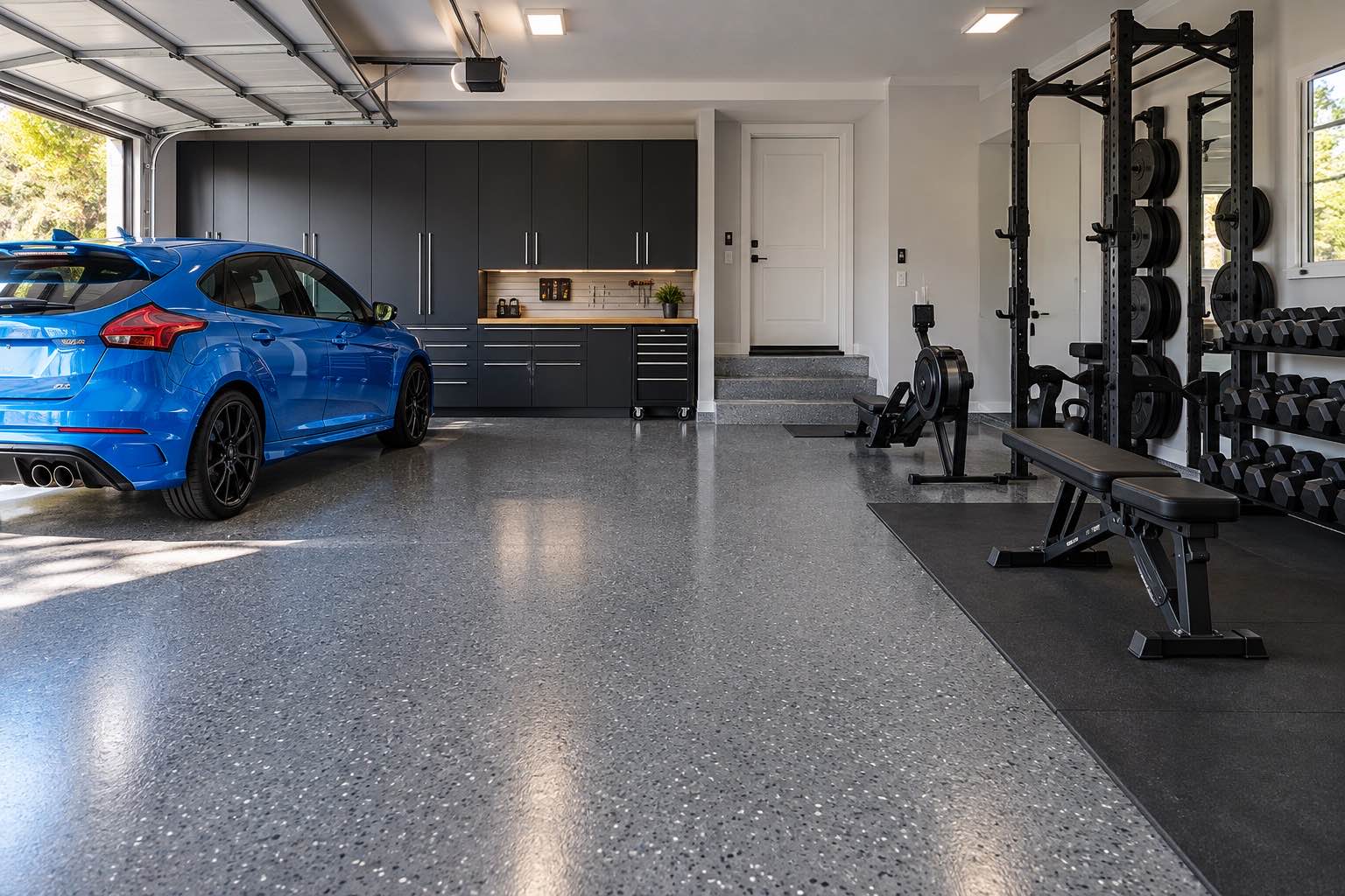 Garage gym with strength equipment and a dark decorative epoxy floor