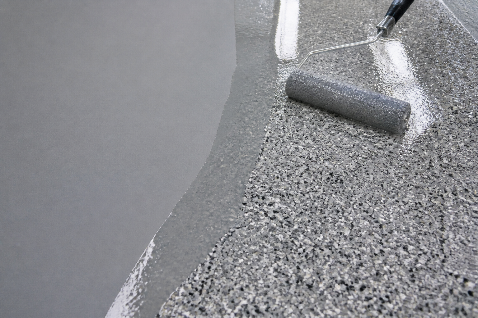 Epoxy base and clear topcoat layers being applied to a garage floor
